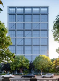 East face of the tower showing a regular grid of aluminium frames and grey glass above a tree line, Greentown ThinkWorks
