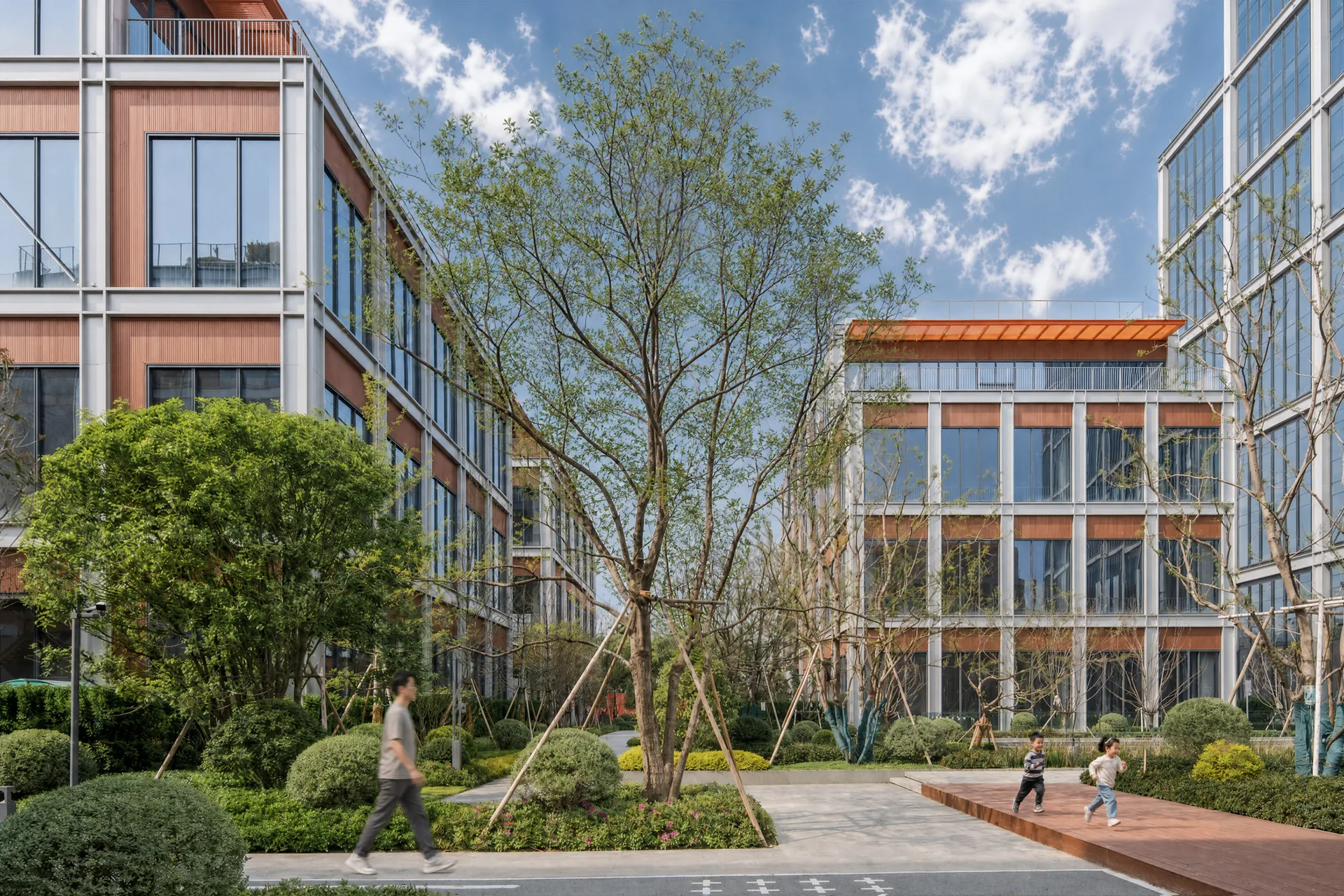 Inner courtyard with a large tree, lawns and benches surrounded by gridded blocks, Greentown ThinkWorks
