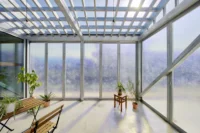 Bright semi outdoor room with a slatted roof, frosted glass walls, plants and a timber bench, House OY by 1-1 Architects