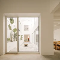 Glass door from the dining area onto the courtyard with tall banana plants