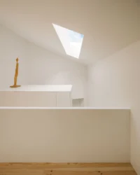 Sloping white ceiling with a skylight above the stair landing
