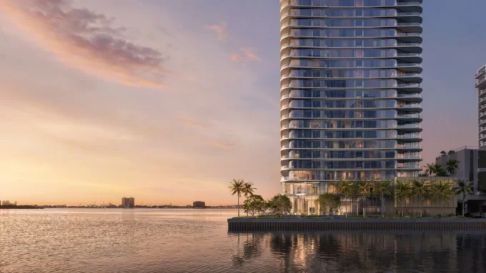 Rendering of the slender Lilli tower with curved balcony edges rising from a palm-lined waterfront at dusk