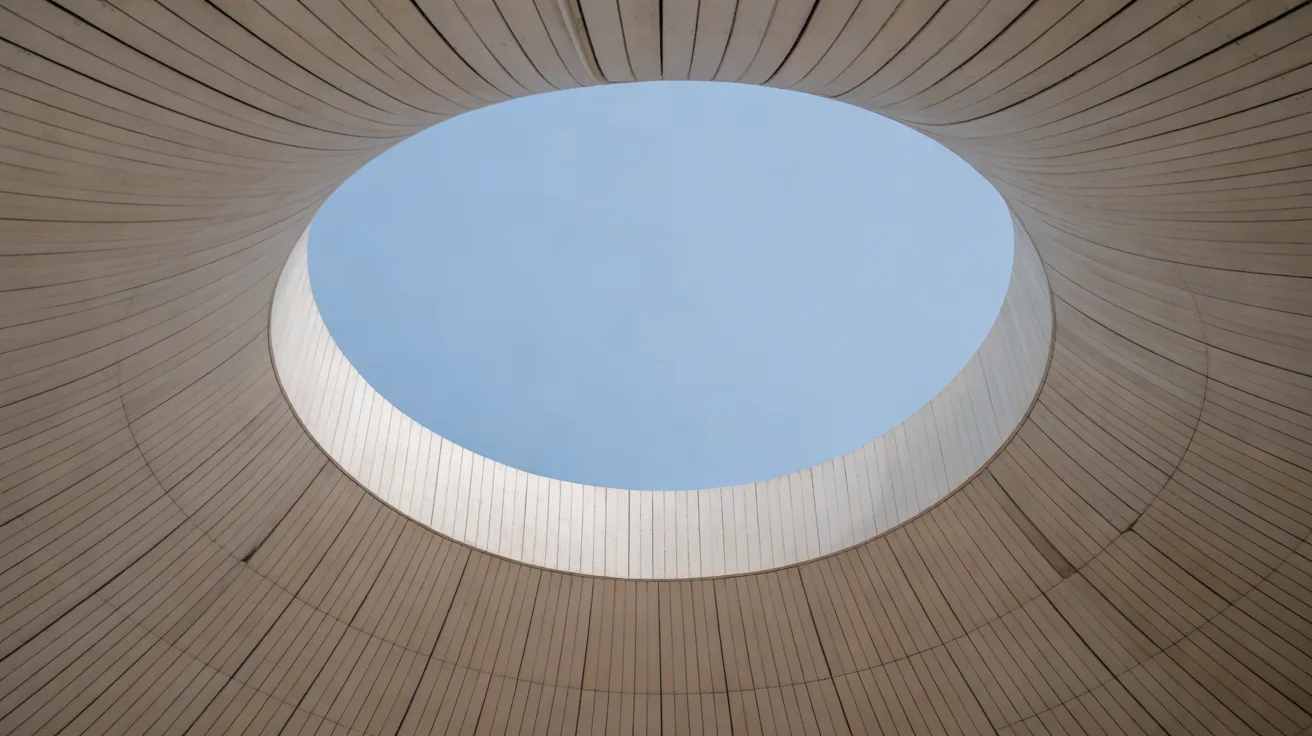Looking up through a circular oculus in a curved timber-lined canopy to a clear blue sky