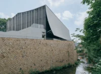 Rear of the theater on a high wall of laid stone beside the watercourse, Moganshan Liaoyuan Theater by One Design