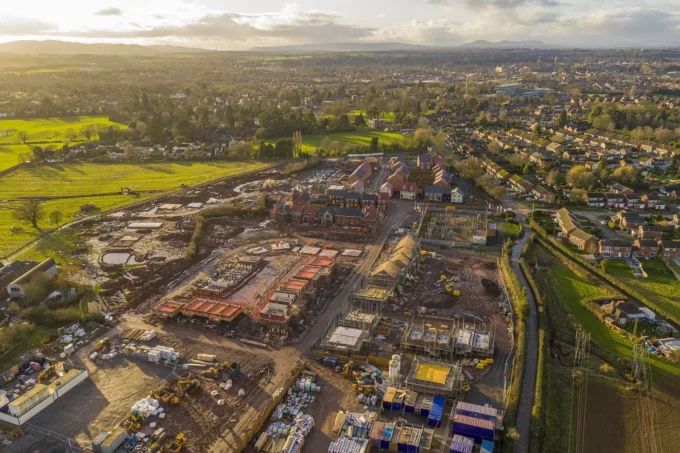 Aerial view of a large housing estate under construction surrounded by existing streets and fields