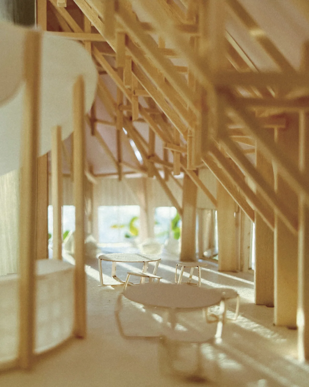 Eye level shot inside a timber model with exposed beams, small furniture and soft daylight