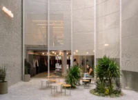 Café tables and planting in the open forecourt in front of a glazed clothing shop