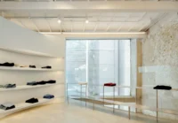 White curved shelves holding folded clothes in a bright room with exposed brick