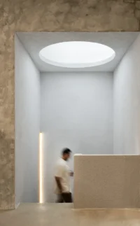Person passing the stone counter under the circular skylight