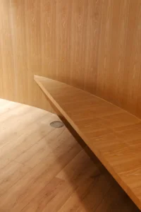 Long curved timber bench running along the wooden wall of the studio