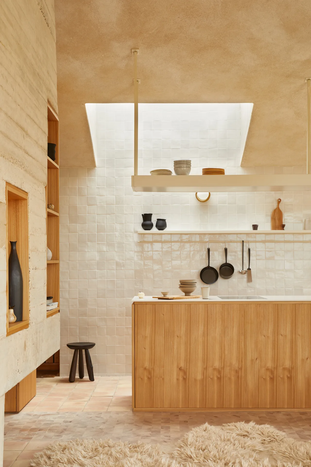 Small kitchen with zellige style tiles, hanging skillets and an elm counter under a skylight, The Makers Barn by HUTCH design