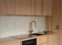 Compact timber kitchen with a pale tiled splashback and copper tap, The Yakisugi Cabin