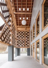 Covered passage beneath the timber lattice with glazed doors and a globe lamp under a coffered ceiling