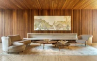 Sitting room with curved sofas and a large painting on a wall of vertical wood boards, Vista House by Studio Gontijo Arquitetura
